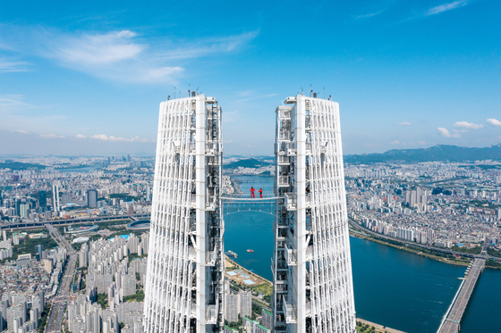 Seoul Sky, the observatory at the top of the Lotte World Tower in Songpa District, southern Seoul, said last week it is launching the ’Sky Bridge Tour“ program this Friday. The new tour is a high-altitude experience at 541 meters (1,775 feet) above ground, where visitors get to walk across the bridge that connects the two separate structures at the very top of the tower. [YONHAP]