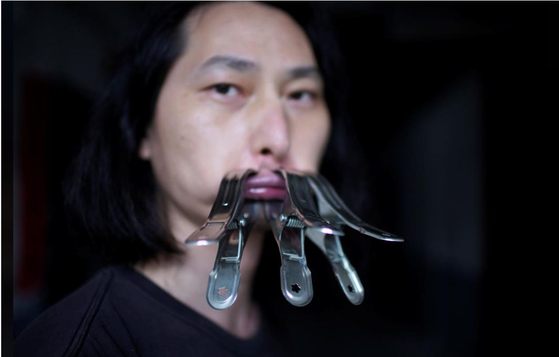Chinese performance artist Brother Nut clamps his mouth shut on July 13 as part of a protest against censorship following the outbreak of coronavirus. [REUTERS/YONHAP]