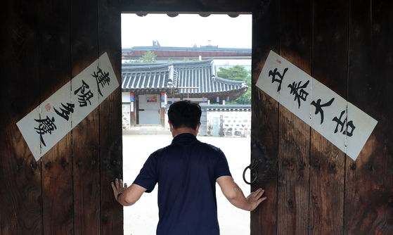 The door to a traditional Korean hanok house is opened Wednesday as the Namsangol Hanok Village in Jung District, central Seoul, welcomed visitors for the first time in weeks due to a surge in Covid-19 cases. Some 65 other cultural facilities in Seoul reopened the same day. [NEWS1]