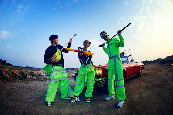 SSAK3 members pose wearing neon-colored outfits while shooting their "Beach Again" music video. [MBC]