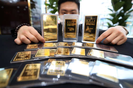 A man displays gold bars at the Korea Gold Exchange office in Jongno District, central Seoul, on Thursday. The price of gold bars on Thursday surged to an all-time high of 72,451 won ($60) per gram since the establishment of the gold trading market in Korea in 2014. [YONHAP]