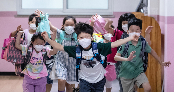 Children who just ended their last day of classes run out of the school in Gangseo District, western Seoul, on Thursday. [NEWS1]