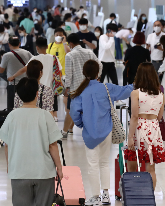 Tourists check in early on Monday morning at the domestic terminal at Gimpo International Airport in Gangseo District, western Seoul, before they take off on their summer vacations. [YONHAP] 