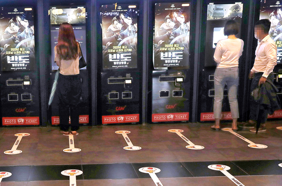 Visitors buy tickets at automated ticket booths in a cinema in Seoul on July 19. [YONHAP]