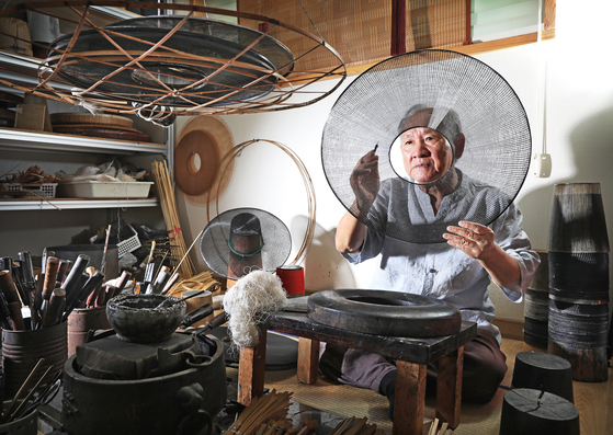 Master craftsman Park Chang-young, who was designated as No.4 intangible cultural property in 2000 for his expertise at making gat, is working on the traditional Korean hat at his studio located in Gwangmyeong, Gyeonggi. [PARK SANG-MOON]