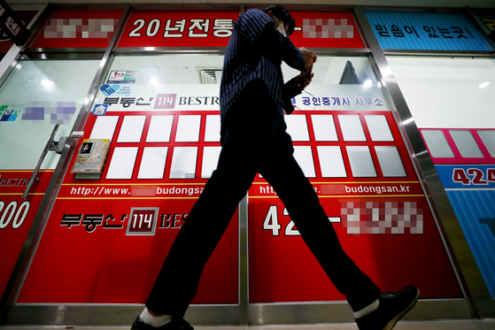 A person walks by an empty bulletin of a real estate agent's office in Songpa District, southern Seoul. [YONHAP]