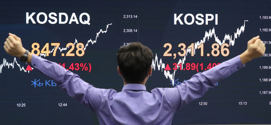 A person cheers in front of the screen with the Kospi close Wednesday in the dealing room of KB Kookmin Bank located in the financial district of Yeouido, western Seoul. The final Kospi surpassed the 2,300 mark, driven by massive purchases by retail "ant" investors, closing at the highest level since October 2018. [NEWS1]