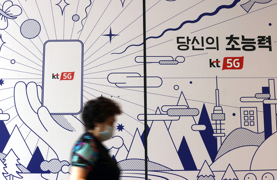 A citizen walks past a phone shop in central Seoul on Wednesday. [YONAHP] 