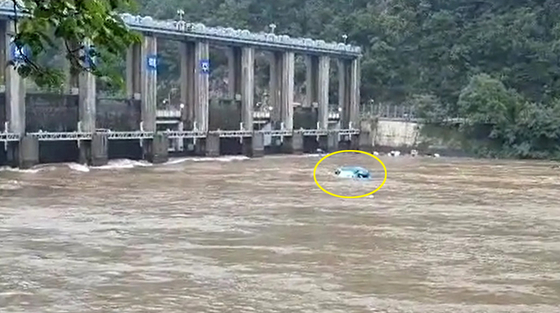 A capsized boat floats towards the Euiam Dam in Chuncheon, Gangwon, after it and two other vessels overturned in an accident caused by rapid waters flows. [YONHAP]