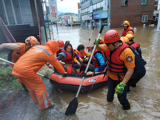 Firefighters rescue people in Gurye County, South Jeolla, on Saturday as the area was flooded by heavy rains. [NEWS1] 