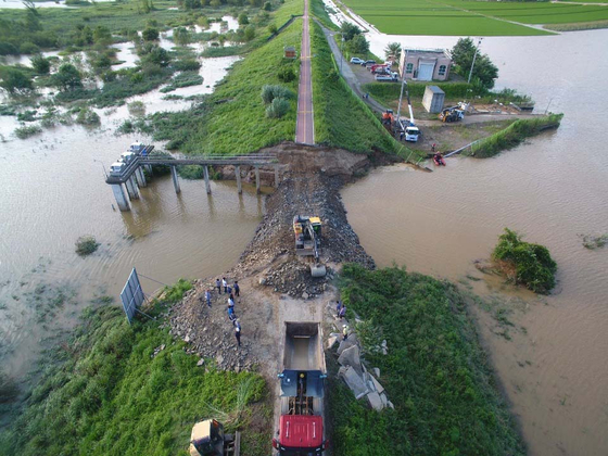 Restoration begins Monday after part of a dike along the Nakdong River in Changnyeong County, South Gyeongsang, was destroyed by heavy rainfalls.  [YONHAP] 