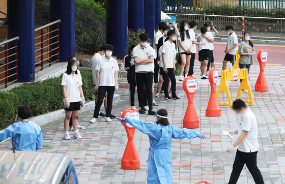Students at Jukjeon High School in Yongin, Gyeonggi, line up to get Covid-19 tests Thursday after several freshman tested positive earlier this week. [YONHAP]