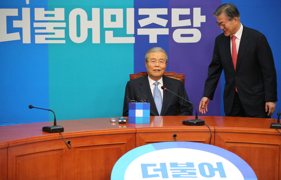 In this file photo, Kim Chong-in, center, sits for a press conference to announce his joining of the Democratic Party on Jan.15, 2016. Moon Jae-in, then the head of the party, stands next to him. [Shin In-seop] 