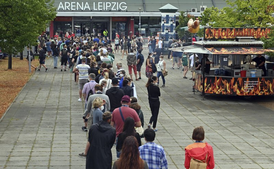 Test participants at a large-scale experiment by the University Medicine Halle/Saale stand at the entrance to the Arena Leipzig in Germany on Aug. 22. Around 2,200 visitors took part in the experiment, titled "Restart-19," in which pop singer Tim Bendzko performed. [AP/YONHAP]