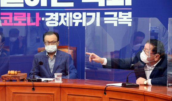 Rep. Kim Tae-nyeon, left, floor leader of the Democratic Party, touches a clear partition placed at his seat at the Supreme Council meeting, on Friday.  [YONHAP] 