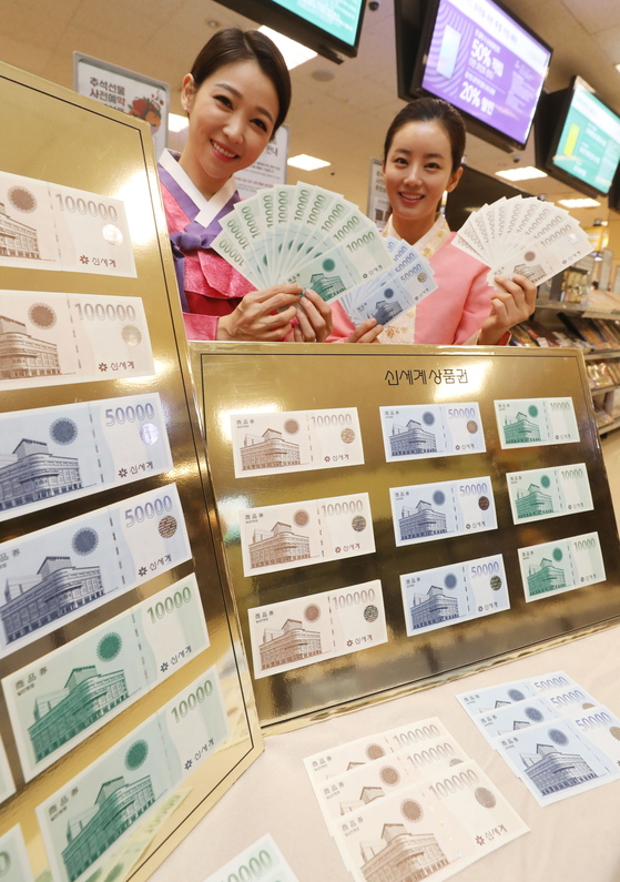Models promote Shinsegae Department Store gift certificates at Emart's Seongsu branch in eastern Seoul on Monday, ahead of the Chuseok harvest festival. Emart sells the gift certificates in its branches across the country and provides additional certificates for people who buy those worth over 10 million won ($8,420). [YONHAP] 