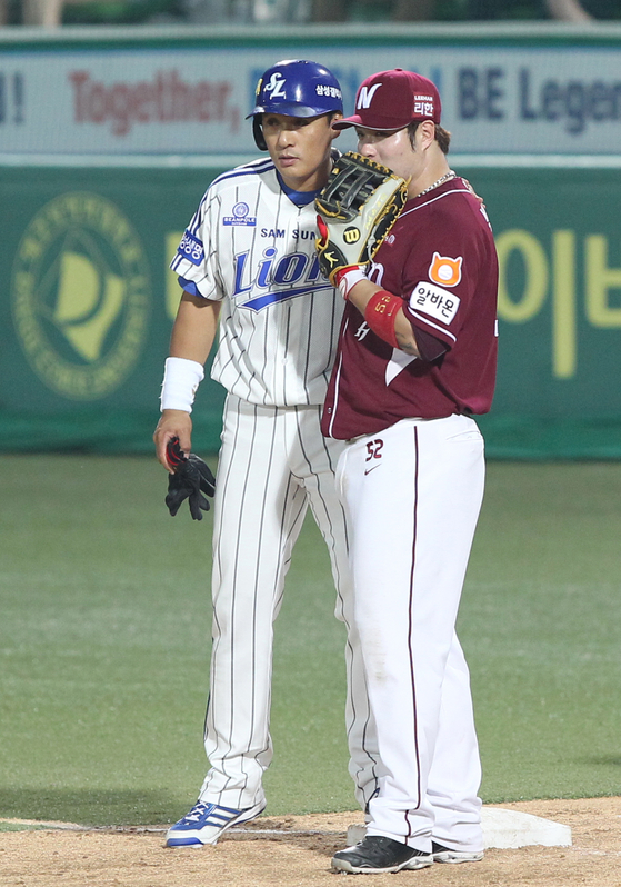Fomer Samsung Lions slugger Lee Seung-yuop, left, and Park Byung-ho of the Kiwoom Heroes talk to each other during a KBO game back in June 24, 2014. [ILGAN SPORTS] 