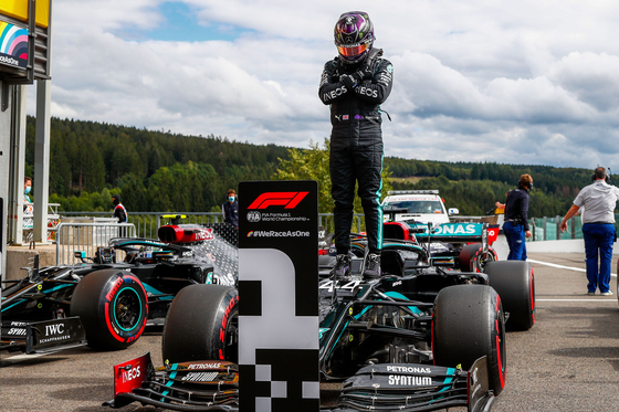 Mercedes' British driver Lewis Hamilton gestures in homage to late U.S. actor Chadwick Boseman, as he stands on his car after securing his 93rd pole position during the qualifying session at the Spa-Francorchamps circuit in Spa on Aug. 29, ahead of the Belgian Formula One Grand Prix.[AFP/YONHAP]