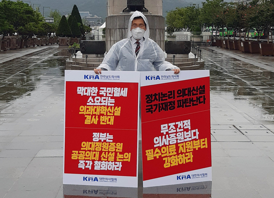 Lee Pil-soo, president of the Jeollanamdo Medical Association and vice president of the Korea Medical Association (KMA), stages a one-man rally in Gwanghwamun Square in central Seoul Wednesday, urging the government to scrap its plans to expand medical school admissions and holding a sign saying, ’Doctors are citizens too.“ [YONHAP]
