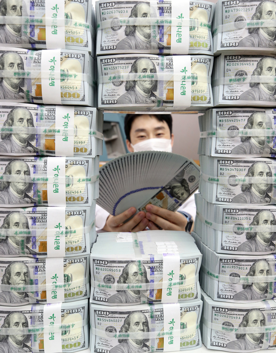 An employee poses with stacks of dollar bills at a Hana Bank branch in Jung District, central Seoul, on Thursday. According to data from the Bank of Korea (BOK), foreign exchange reserves came to $418.95 billion as of the end of August, up $2.4 billion from a month earlier. Korea's foreign exchange reserves have been increasing for five consecutive months. [YONHAP] 