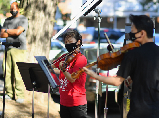Violinist Quan Ge (left) and violist Cong Wu of the New York Philharmonic play with their "bandwagon's pop-up concert series" at Betty Carter Park on Sept. 4 in New York City. [AFP/YONHAP]
