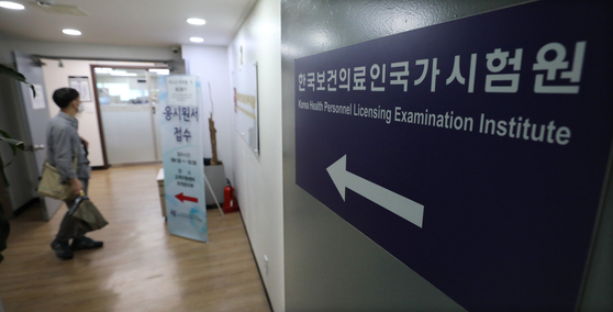 A mans stares at the registration sign at the Korea Health Personnel Licensing Examination Institute in Gwangjin District, eastern Seoul, a day before the 85th Korean Medical License Examination kicks off. The Health Ministry said Monday that the medical exam, already postponed once, will be carried out as scheduled despite only 14 percent out of 3,172 medical students having applied for it amid a boycott over increasing medical school admissions. [NEWS1]