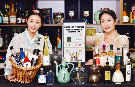 Models promote traditional Korean alcoholic beverages at The Sool Gallery in Gangnam District, southern Seoul, on Monday. Drinks can be ordered online ahead of the Chuseok harvest festival. People who place orders will be given additional gifts such as discount coupons from the Ministry of Agriculture, Food and Rural Affairs and Korea Agro-Fisheries & Food Trade Corporation. [YONHAP]
