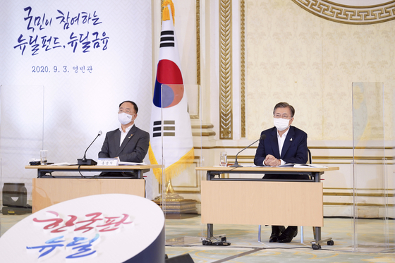 On Sept. 3 at the Blue House, President Moon Jae-in, right, is briefed by Finance Ministry officials on how to create a Korean New Deal fund aimed at drawing investments from ordinary citizens. To his left is Deputy Prime Minister Hong Nam-ki, who also serves as Finance Minister. [JOINT PRESS CORPS]