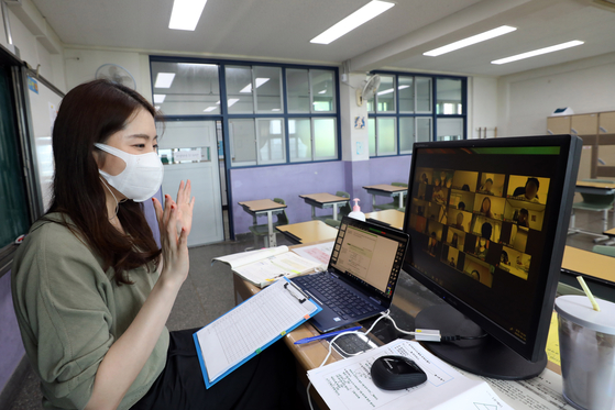 A teacher at Bongeun Middle School in Gangnam District, southern Seoul, conducts an interactive online class with her students on Aug. 26 after schools in the capital area reverted to remote learning because of a spike in coronavirus cases. However, parents are complaining that their children spend most of their time watching prerecorded lessons instead, while some students have yet to have face time with their teachers in the new fall semester. [NEWS1]