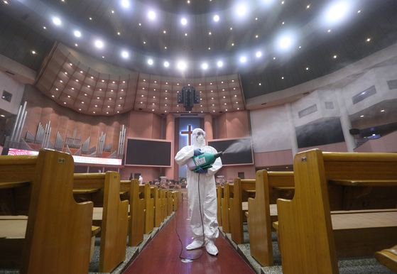 Workers disinfect the Yoido Full Gospel Church in Yeouido, western Seoul, Tuesday, after three adherents tested positive for the coronavirus. All churches in Seoul, Incheon and Gyeonggi have been banned from holding activities, including services and prayer groups, until Aug. 30. [NEWS1]