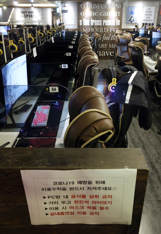 Visitors play online games at an internet cafe in Seongdong District, eastern Seoul, on Monday afternoon. Starting Monday, internet cafes were allowed to reopen nationwide, but with some new restrictions: Minors are not allowed, eating is prohibited and customers must spread out. [YONHAP]
