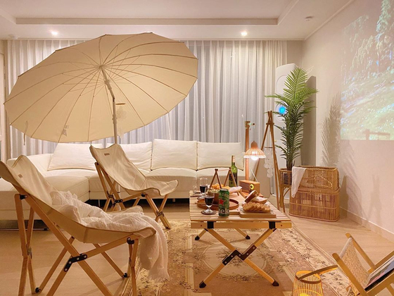With a few foldable chairs, a table and beam projector, the camping atmosphere is complete. [CHO SU-JEONG]