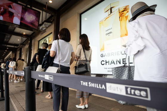Visitors at Shilla Duty Free in Jangchung-dong in Jung District of central Seoul wait in line on July 21 to shop luxury items that were made available for the public for a limited time in July. [NEWS 1]