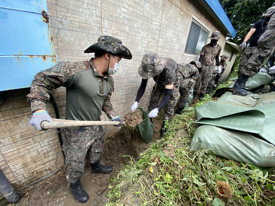 Soldiers from the Korean Army’s 22nd Infantry Division take part in typhoon recovery efforts around the house of an elderly veteran in Goseong County, Gangwon, Thursday. [YONHAP]