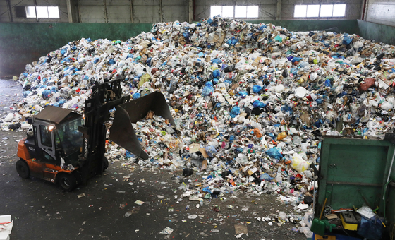 An employee of a waste-sorting firm separates the accumulated waste with an excavator at a recycling center inside a park in Songpa District, southern Seoul. [NEWS1]
