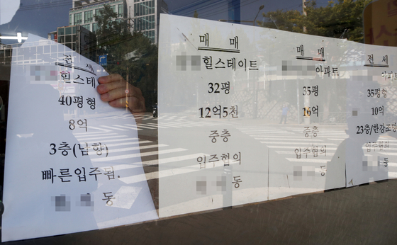 A jeonse offering post being taken down at a real estate agency in Mapo District, western Seoul, on Tuesday. Jeonse offerings have been drying up fast, especially in Gangnam District, southern Seoul, since the National Assembly passed legislation that protects tenants, including automatic extension and a cap on rent increases. [YONHAP]