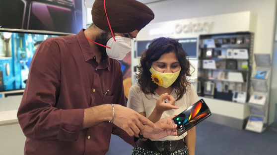 Customers in India look at Samsung's new Galaxy Z Flip at an exhibition hall in Gurugram, India. [SAMSUNG ELECTRONICS]