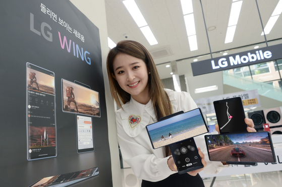 A model holds up LG Electronics' "swiveling" Wing smartphone. [LG ELECTRONICS]