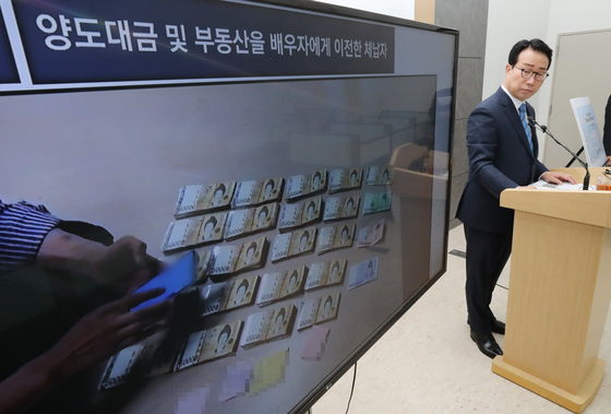 Hidden cash found at the residency of one of the tax evaders being displayed on screen during the National Tax Service's press briefing held at Sejong Government Complex on Monday. [YONHAP]