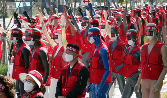 Protesters from across the nation stand alongside mannequins, to fill out the socially-distanced rally, as they protest against plans to scrap facility maintenance businesses in front of the Ministry of Land, Infrastructure and Transport at the Sejong Government Complex on Wednesday. [YONHAP]