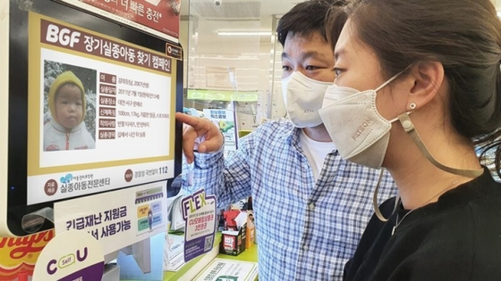 People look at CU’s point-of-sale screen that displays photos and information of missing children. [BGF RETAIL] 