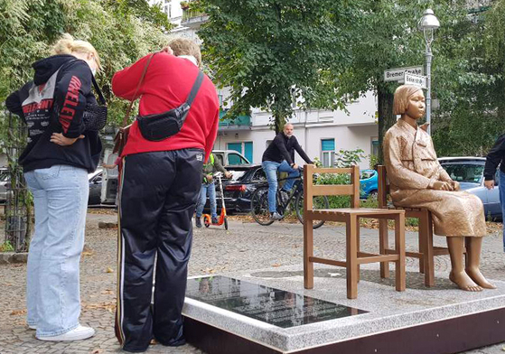 People look at a "comfort woman" statue, symbolizing Korean victims of wartime sexual slavery by the imperial Japanese army during World War II, erected in Berlin, Germany, on Sept. 27. [YONHAP] 