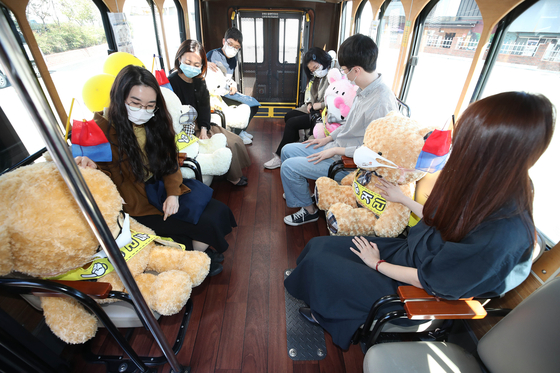 Stuffed dolls are placed on every other seat of a tour bus in Daegu Wednesday to guarantee social distancing among passengers. [YONHAP] 