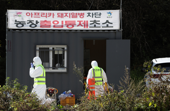 Quarantine workers restrict entry into a farm confirmed to be infected with African swine fever in Hwacheon,Gangwon on Sunday. [YONHAP]