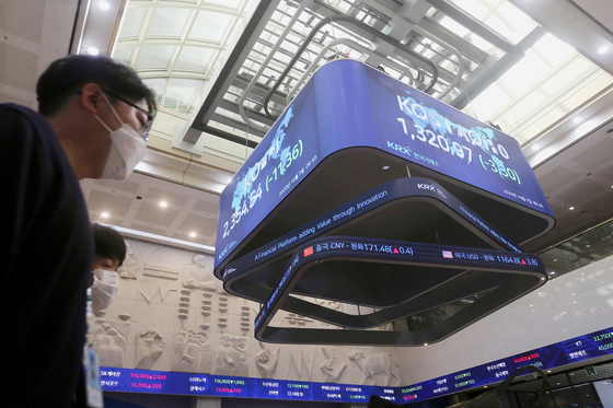 People walk under screens at the Korea Exchange in Yeouido, western Seoul on Oct. 7. [ASSOCIATED PRESS]