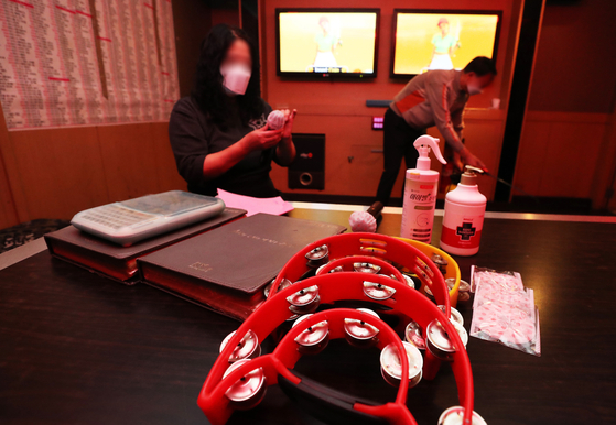 Noraebang (singing room) operator in Seongnam, Gyeonggi, sterilizing facilities on Monday, as the social distancing restriction has been relaxed to Level 1 from Level 2. [YONHAP]