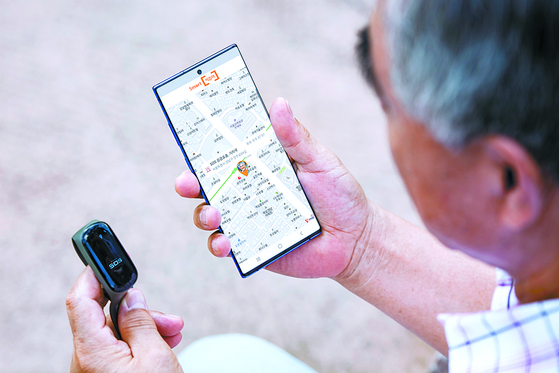 A senior citizen looks at his smartphone for location information. [YONHAP] 