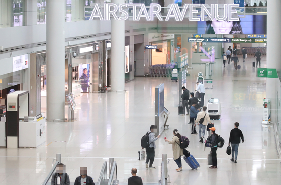 Customers walk around the departure terminal where duty-free stores are located at Incheon International Airport on Tuesday. The government held a third round of bidding for duty-free business licensing at the airport’s Terminal 1, but failed to attract interested parties. Only one mid-size company bid for six units covering 6,131 square meters (66,000 square feet). [YONHAP]