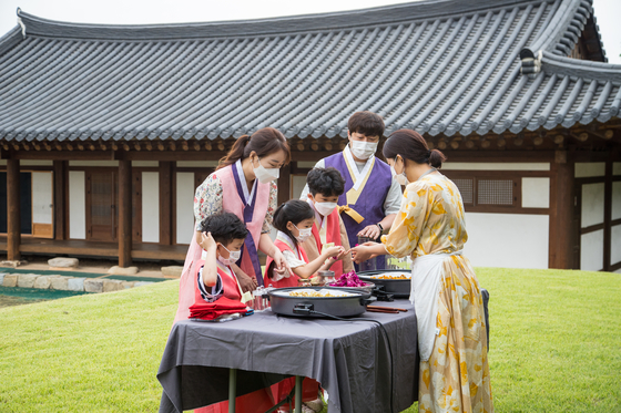 Lee Bong-yong, center, Kim Gi-yang, second from left, and their children make flower tea at Sachon Village. [CHOI SEUNG-PYO]