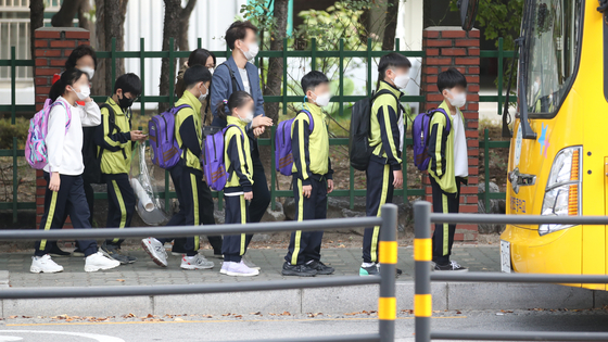 Students line up for a school bus in Nowon District, northern Seoul, Monday. Social distancing measures have been eased from Level 2 to Level 1, and Seoul education authorities said students will soon be allowed to go to school more often than before. [NEWS1]